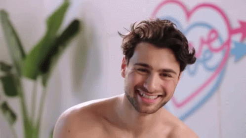 Shirtless Man Smiling at Pink and Blue Heart With Love