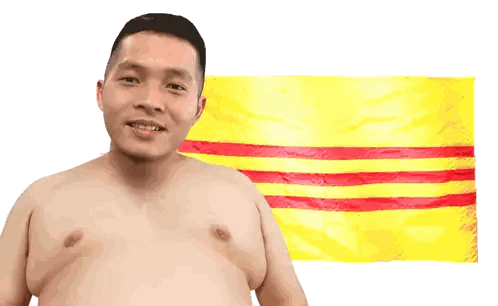 Shirtless Man Smiling in Front of Flag