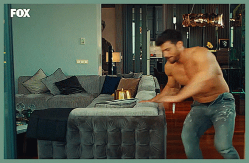 Shirtless Man Standing in Front of Couch With Fox Logo