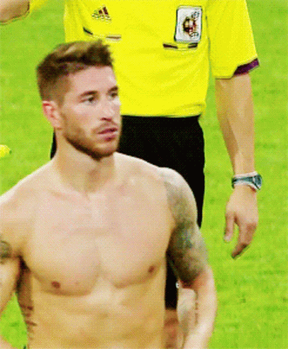 Shirtless Man Standing on Field With Referee