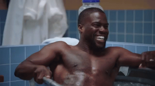 Shirtless Man Taking Bath in Bathtub With Hose