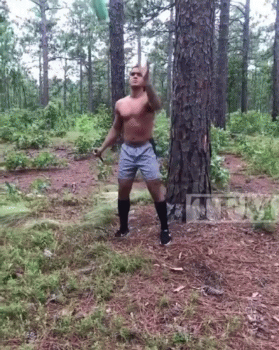 Shirtless Man Throwing Frisbee In Forest GIF