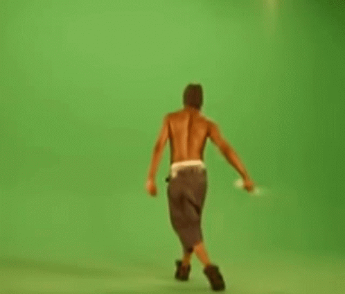 Shirtless Man Walking On Green Screen Holding Stick GIF