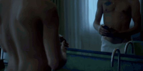 Shirtless Man With Chest Tattoo Looking at Phone