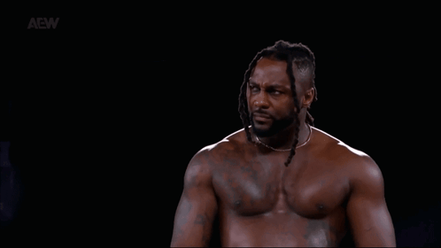 Shirtless Man with Dreadlocks in Dark Room