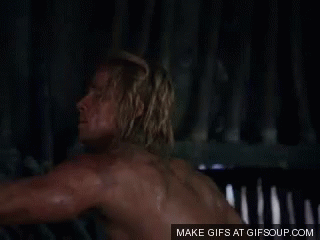 Shirtless Man With Hands On Hips By Fence GIF