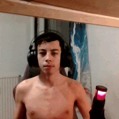 Shirtless Man With Headphones Holding Red Light