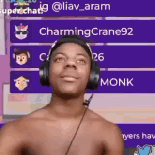 Shirtless Man With Headphones in Front of Purple Wall