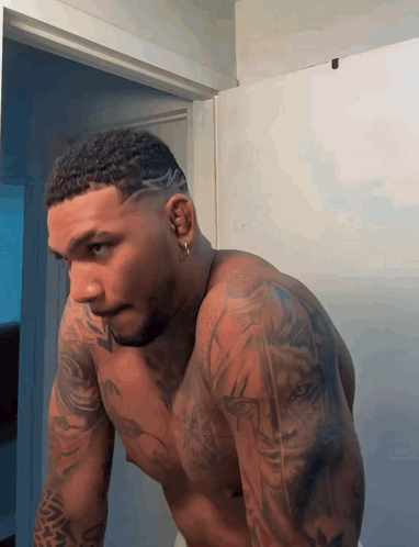 Shirtless Man With Tattoos Looking In Mirror GIF