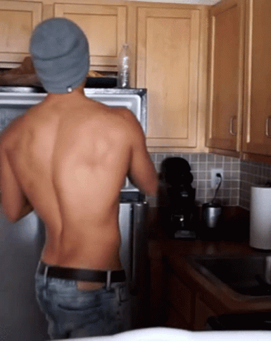 Shirtless Man With Water Bottle in Refrigerator