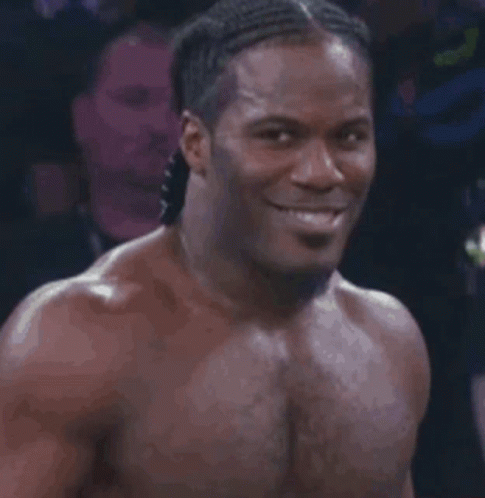 Shirtless Smiling Man in Dark Room