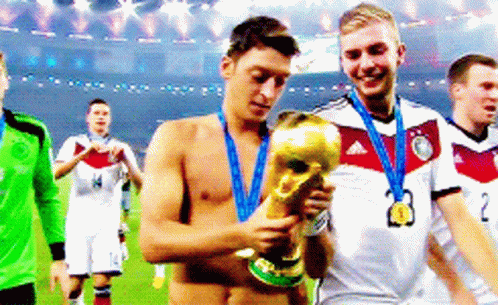Shirtless Soccer Player Holding Trophy With Medal