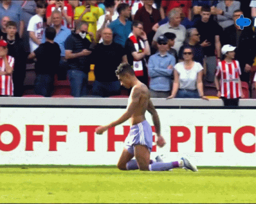 Shirtless Soccer Player Kneeling In Front Of Off The Pitch Sign GIF