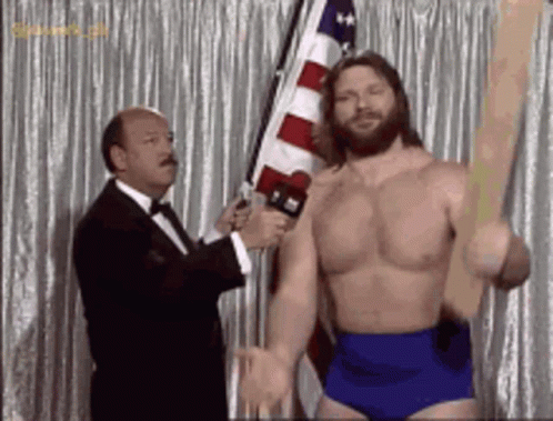 Shirtless Wrestler Holding Flag Interviewed by Tuxedo Man