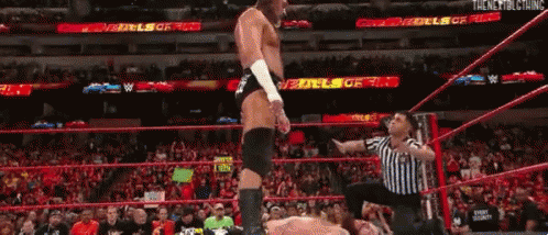 Shirtless Wrestler In Front Of Big Cass Sign GIF