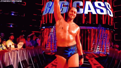 Shirtless Wrestler In Front Of Big Cass Sign GIF