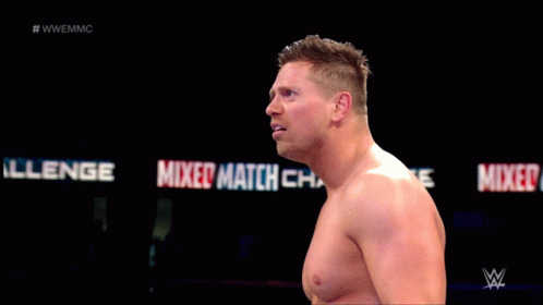 Shirtless Wrestler Standing in Front of Mixed Match Sign