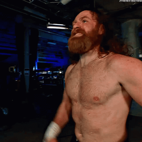 Shirtless Wrestler With Beard in Dark Room