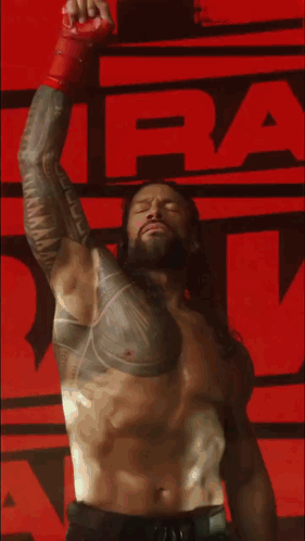 Shirtless Wrestler With Chest Tattoo Raising Arm GIF