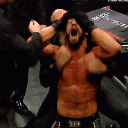 Shirtless Wrestler With Mouth Open Surrounded by People
