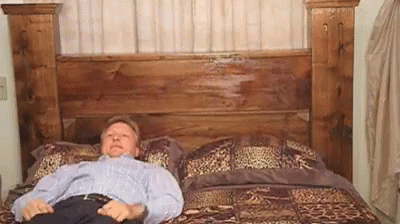 Man Retrieving Shotgun From Bed GIF