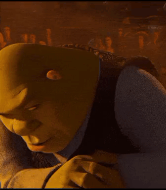 Shrek From Shrek Is Smiling And Looking At The Camera In A Dark Room . GIF