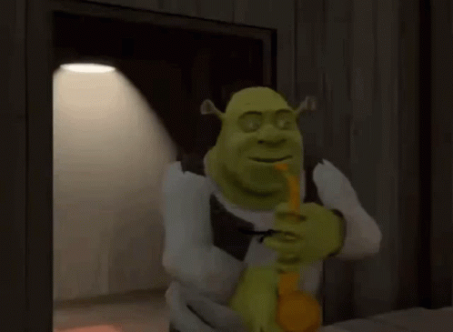 Shrek Is Holding A Pencil In His Mouth And Smiling While Standing In Front Of A Door . GIF