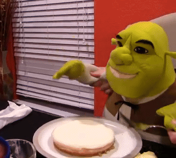 Shrek Is Pointing At A Piece Of Cake On A White Plate GIF