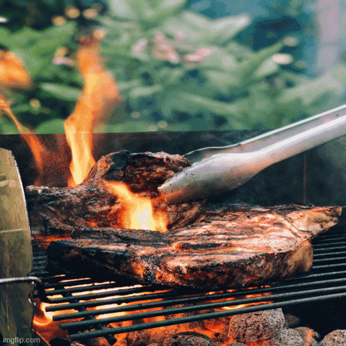 Shrimp and Meat Cooking on Grill With Vegetables