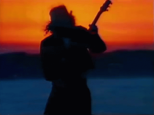 Silhouette Of Man Playing Guitar At Sunset GIF