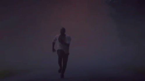 Silhouette of Man Running in Foggy Forest