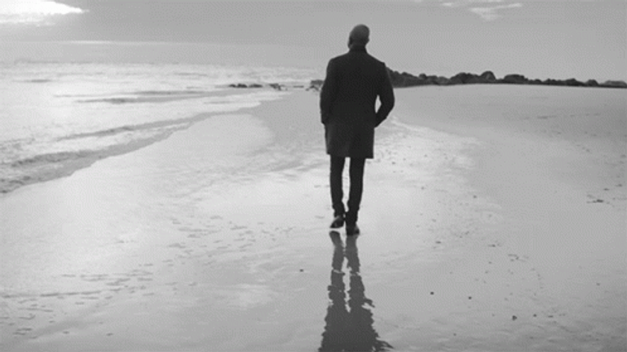 Silhouette Of Man Walking Away On Beach GIF