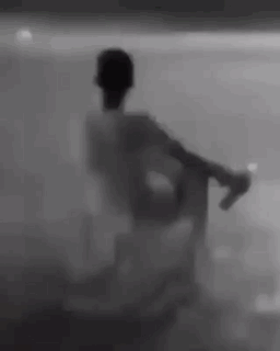 Silhouette Sitting in Chair Behind Glass Wall