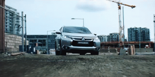 Silver Mitsubishi Driving Down Gravel Road