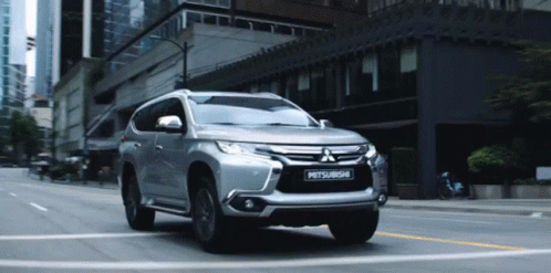 Silver Mitsubishi SUV Driving on City Street