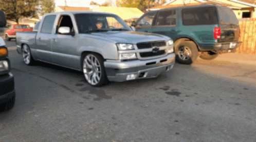 Silver Pickup Truck Next To Green Van GIF