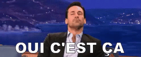 Sitting Man in Suit with Oui C'est Ca Sign