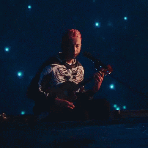 Skeleton Shirt Man Plays Guitar in Dark Room