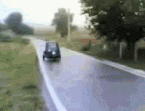 Small Car Driving Down Road