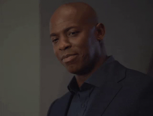Smiling Bald Man in Suit and Black Shirt