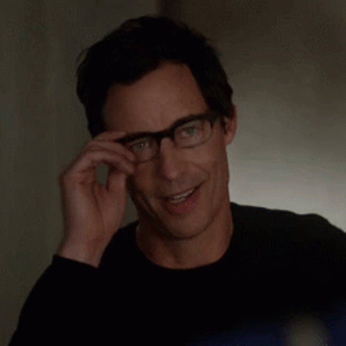 Smiling Man Adjusting Glasses in Black Shirt
