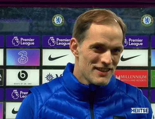 Smiling Man In Blue Jacket With Premier League Banner GIF