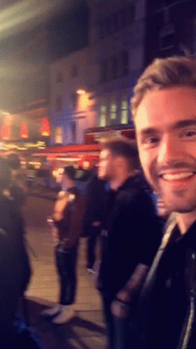 Smiling Man in Front of Crowd
