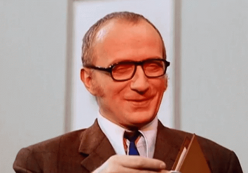 Smiling Man in Glasses and Suit Holding Book