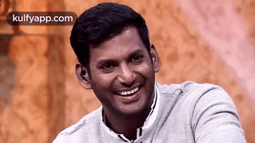 Smiling Man in Gray Sweater Sitting