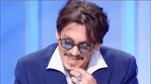 Smiling Man in Suit and Sunglasses Holding Chin