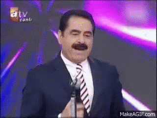 Smiling Man in Suit and Tie Holding Microphone