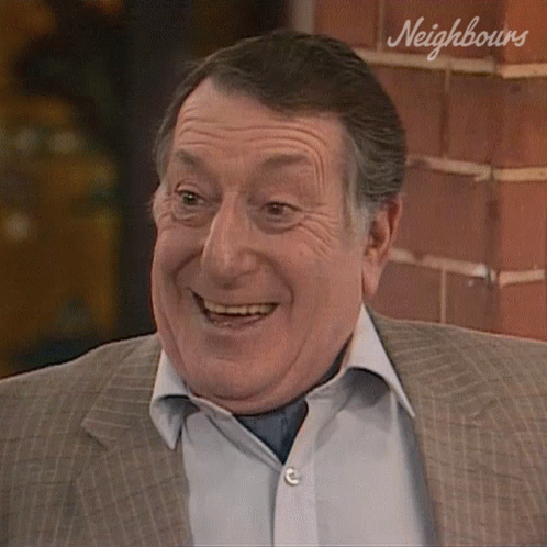 Smiling Man In Suit By Neighbours Brick Wall GIF