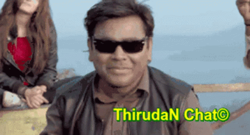 Smiling Man in Sunglasses in Front of Thiruda Chat Sign