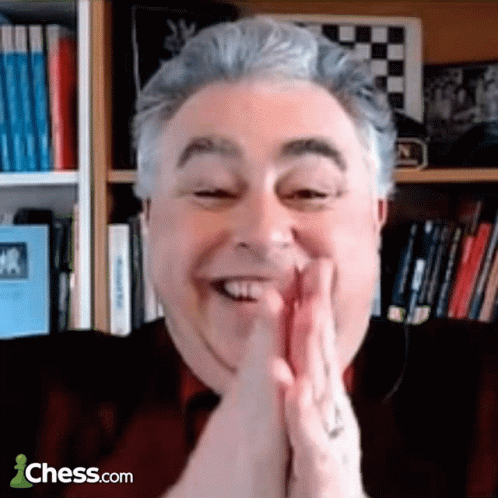 Smiling Man With Folded Hands at Chess.com Bookshelf